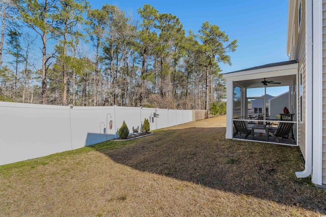 view of yard with a fenced backyard and ceiling fan