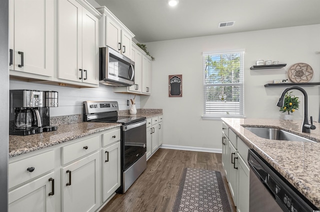 kitchen featuring a sink, visible vents, white cabinetry, appliances with stainless steel finishes, and dark wood finished floors