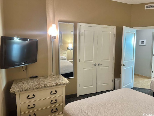 bedroom featuring baseboards, visible vents, and a closet