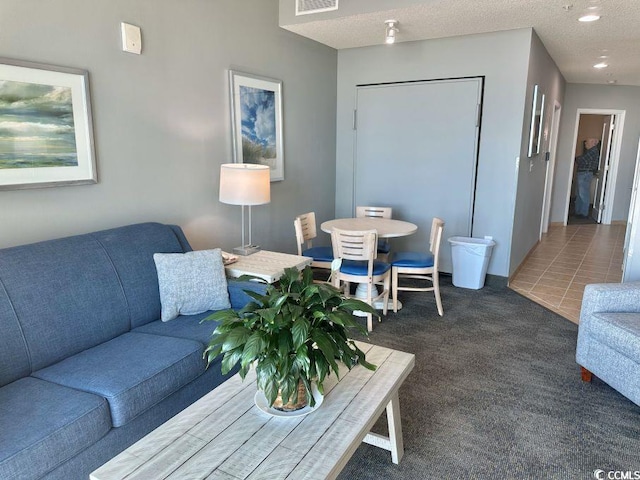 living room with a textured ceiling, carpet floors, visible vents, and recessed lighting