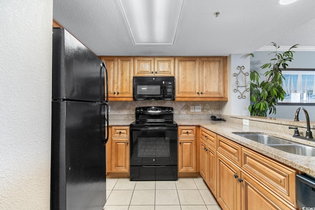 kitchen with light tile patterned floors, a sink, black appliances, a textured ceiling, and backsplash