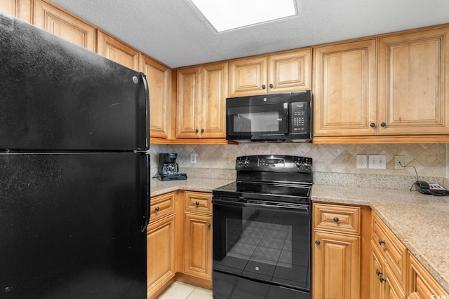 kitchen with light tile patterned floors, decorative backsplash, a textured ceiling, and black appliances