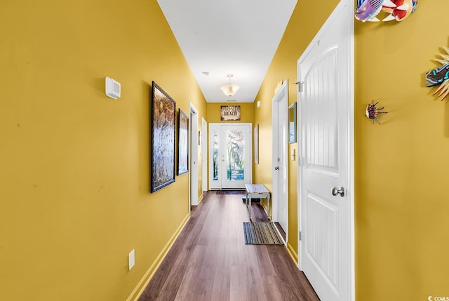 corridor featuring dark wood-style flooring and baseboards