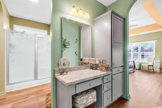 full bath with a stall shower, wood finished floors, and vanity