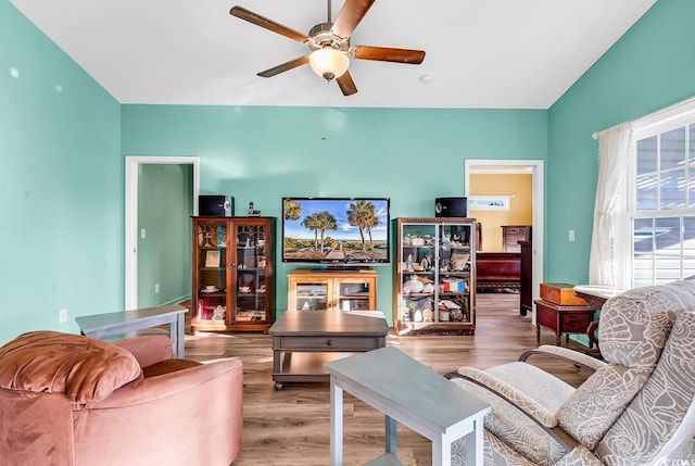 living room with ceiling fan, vaulted ceiling, and wood finished floors