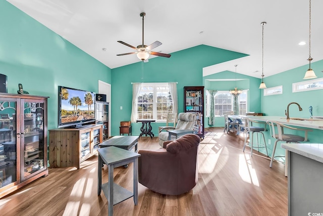 living area with lofted ceiling, ceiling fan, and wood finished floors