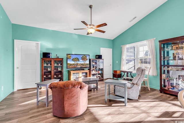 living room with a ceiling fan, visible vents, and wood finished floors