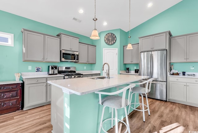 kitchen with appliances with stainless steel finishes, gray cabinets, a sink, and visible vents