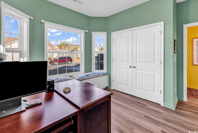 office with light wood-type flooring, a wealth of natural light, visible vents, and baseboards