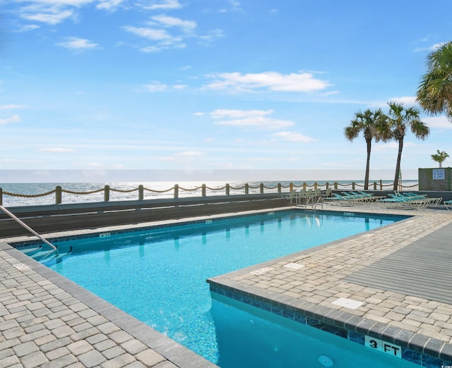 pool featuring a patio area and a water view