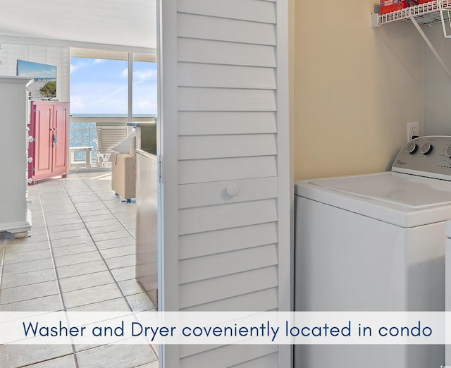 washroom featuring washer / dryer, light tile patterned floors, and laundry area