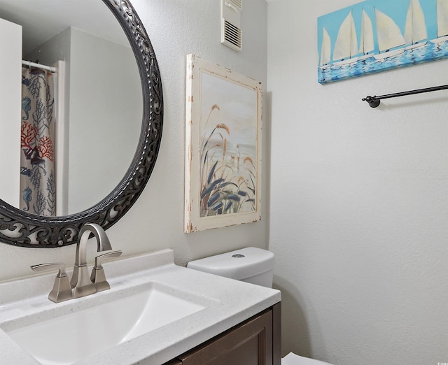 full bathroom with toilet, visible vents, and vanity