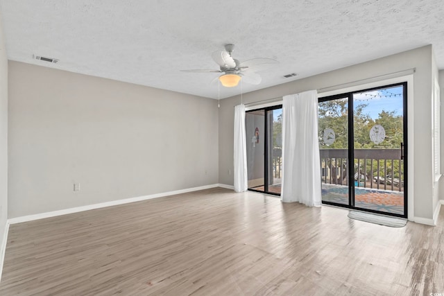 empty room featuring baseboards, visible vents, and wood finished floors