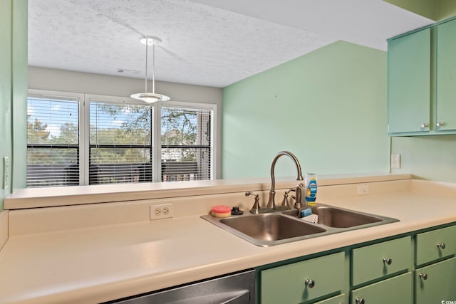 kitchen with a sink, a textured ceiling, light countertops, and green cabinetry