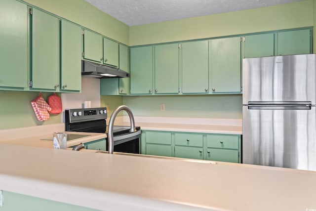 kitchen featuring a textured ceiling, stainless steel appliances, light countertops, and under cabinet range hood