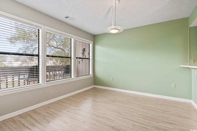 310 5th Ave N Unit 206, Surfside Beach, SC 29575 - spare room featuring light wood-type flooring, a textured ceiling, and baseboards
