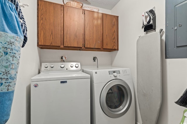 laundry room featuring cabinet space, washing machine and dryer, electric panel, and a textured ceiling