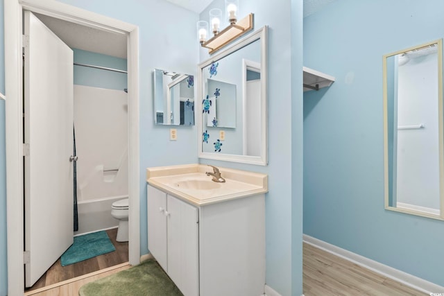 full bathroom with toilet, wood finished floors, vanity, and baseboards