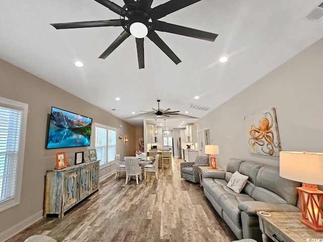 living room featuring vaulted ceiling, wood finished floors, visible vents, and recessed lighting