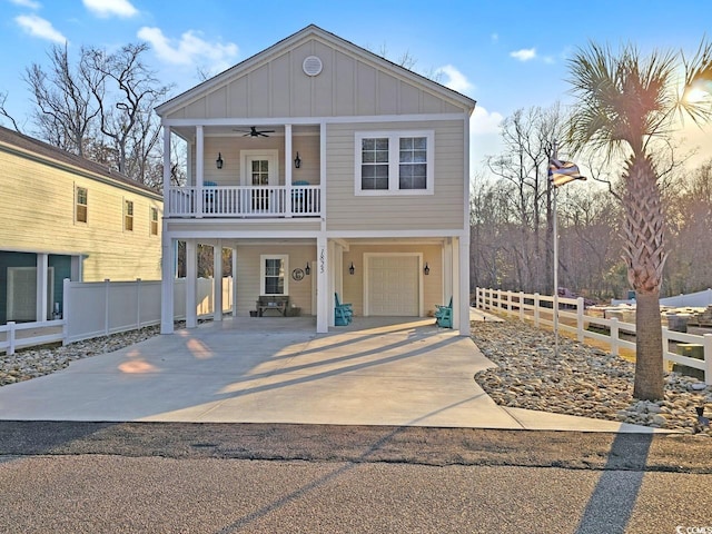 view of front of house featuring board and batten siding, fence, a ceiling fan, and concrete driveway