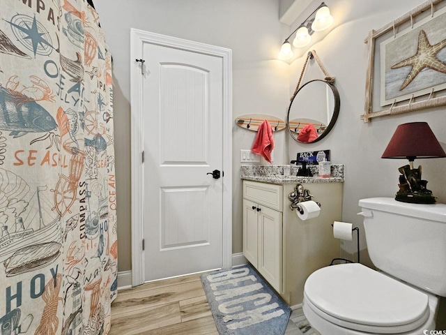 full bathroom featuring vanity, toilet, and wood finished floors