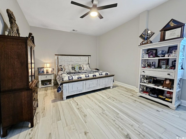 bedroom with a ceiling fan, light wood-type flooring, visible vents, and baseboards