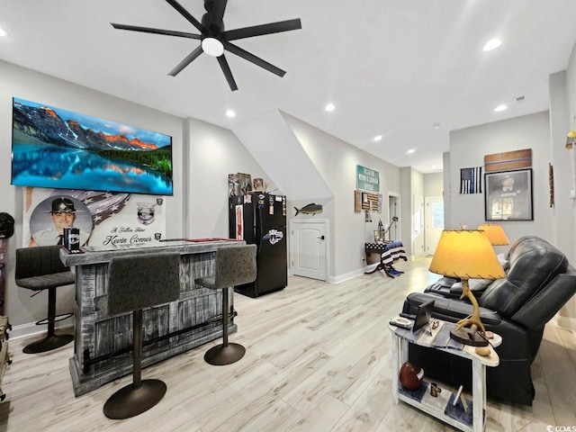 living area with ceiling fan, recessed lighting, baseboards, light wood-style floors, and a dry bar