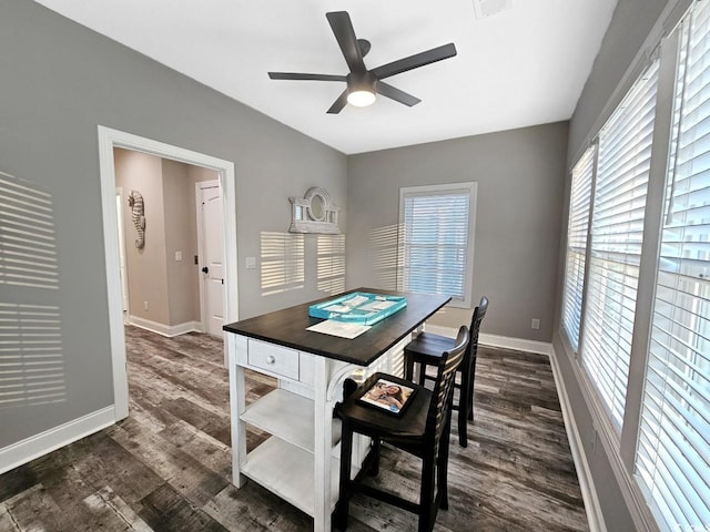 dining area with dark wood-style floors, ceiling fan, visible vents, and baseboards