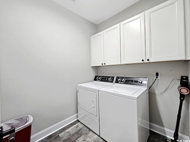 washroom featuring dark wood-type flooring, cabinet space, independent washer and dryer, and baseboards