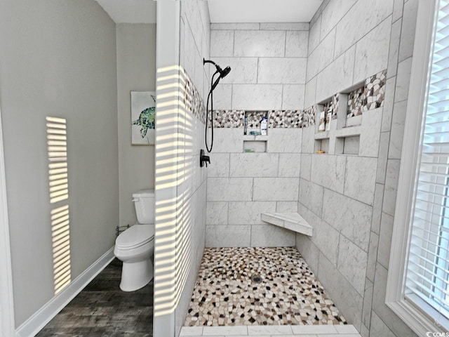 full bathroom featuring wood finished floors, walk in shower, toilet, and baseboards