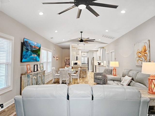 living room featuring light wood-style floors, visible vents, vaulted ceiling, and recessed lighting