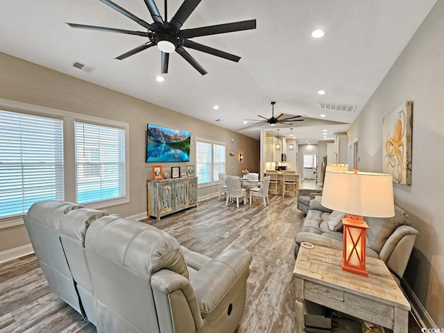 living area with light wood-style floors, lofted ceiling, visible vents, and recessed lighting