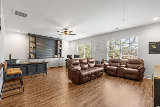 living room featuring ceiling fan, wood finished floors, and visible vents