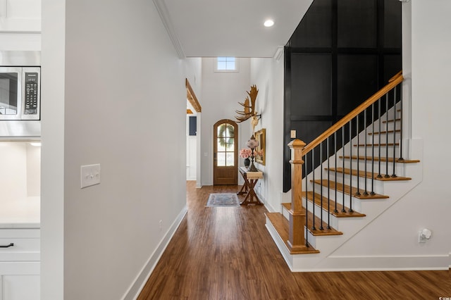 foyer with stairway, baseboards, and wood finished floors