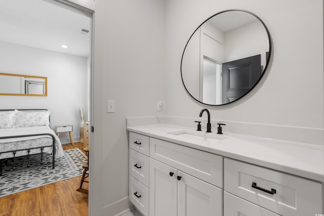 bathroom featuring recessed lighting, wood finished floors, vanity, visible vents, and baseboards