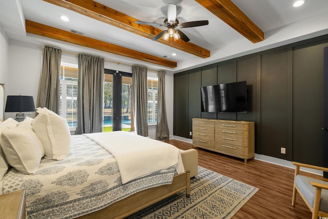 bedroom featuring a decorative wall, visible vents, french doors, beam ceiling, and dark wood finished floors