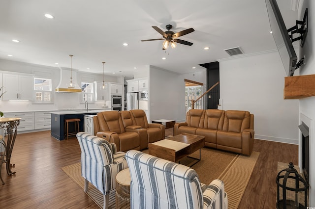 living area with dark wood-type flooring, a fireplace, visible vents, and baseboards