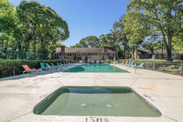 pool with a patio and fence