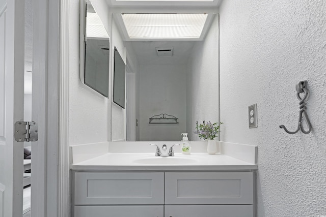 bathroom with vanity and a textured wall