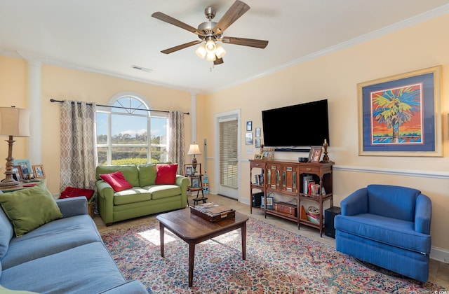 living room featuring baseboards, visible vents, a ceiling fan, and crown molding