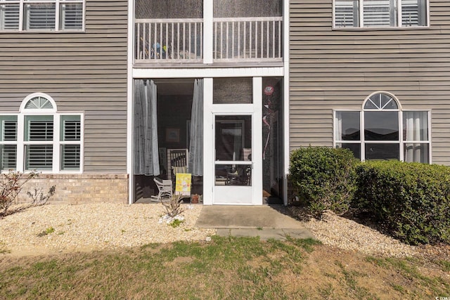 view of exterior entry featuring a balcony