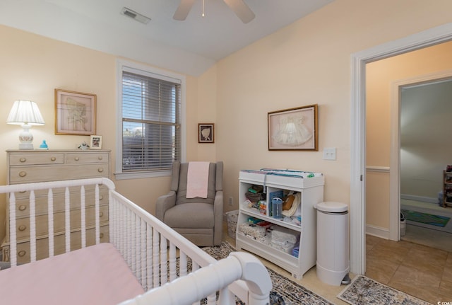 tiled bedroom with ceiling fan, a crib, and visible vents