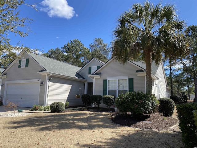 view of front facade featuring a shingled roof and driveway