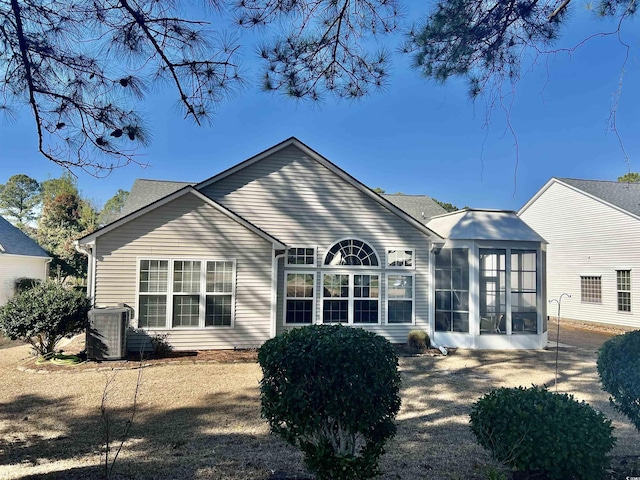 rear view of property with a sunroom and central AC unit