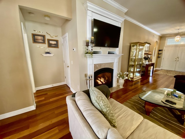 living area featuring ornamental molding, wood finished floors, a high end fireplace, and baseboards