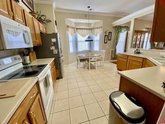 kitchen featuring light tile patterned floors, crown molding, white appliances, light countertops, and pendant lighting