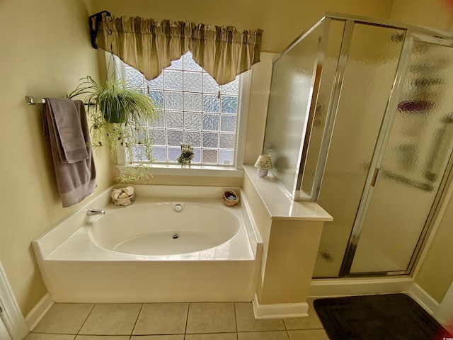 full bathroom featuring baseboards, a stall shower, a garden tub, and tile patterned floors