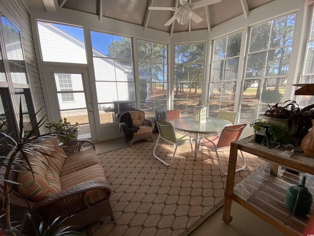 sunroom / solarium with beamed ceiling and a ceiling fan