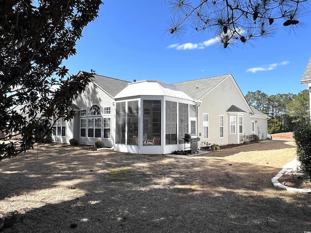 rear view of property featuring a sunroom