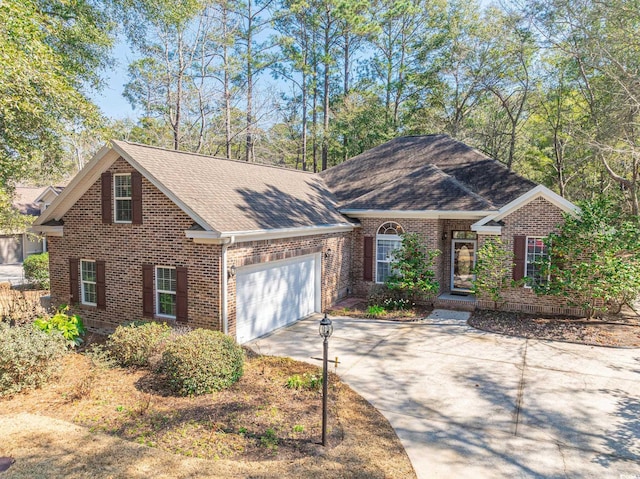 view of front of home with a garage, driveway, roof with shingles, and brick siding